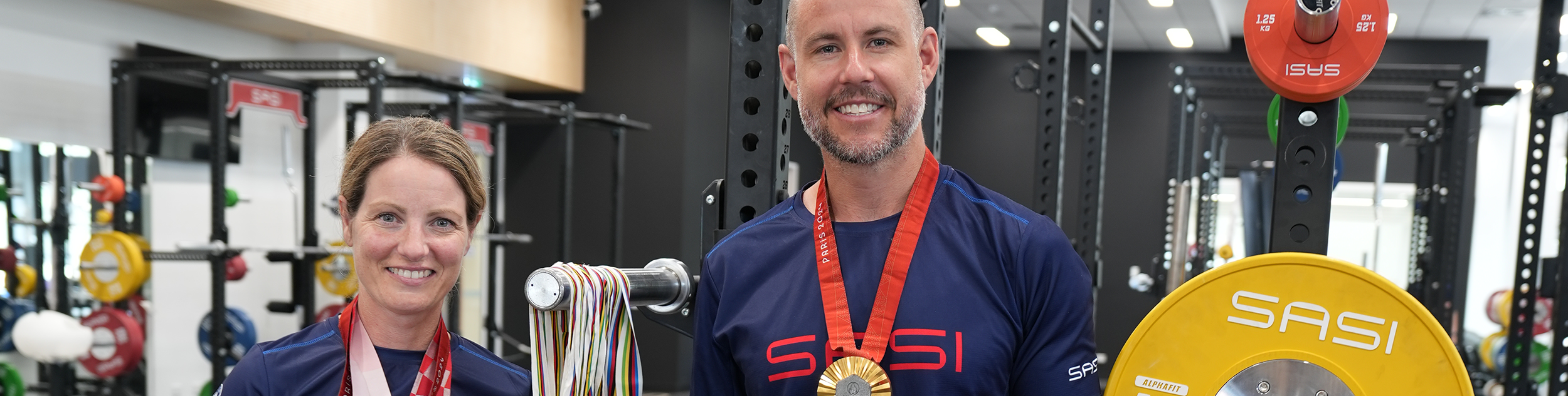Emily and Jed standing with their gold medals