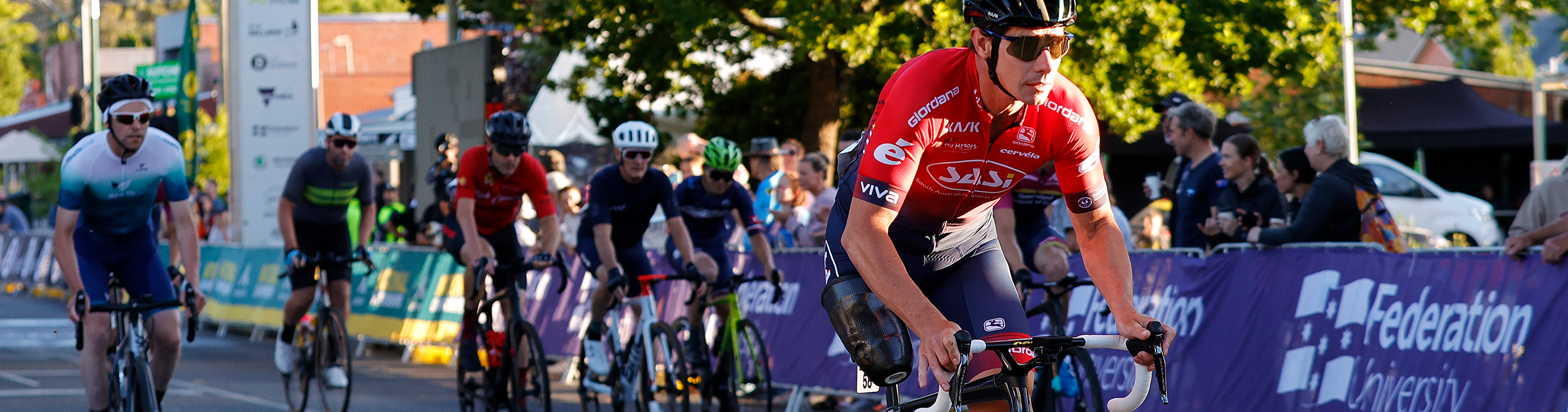 Darren Hicks riding on his bike ahead of other cyclistss