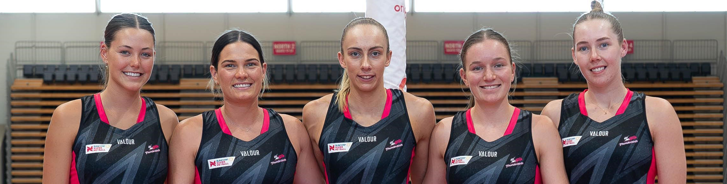 Five Adelaide Thunderbirds players standing in a row
