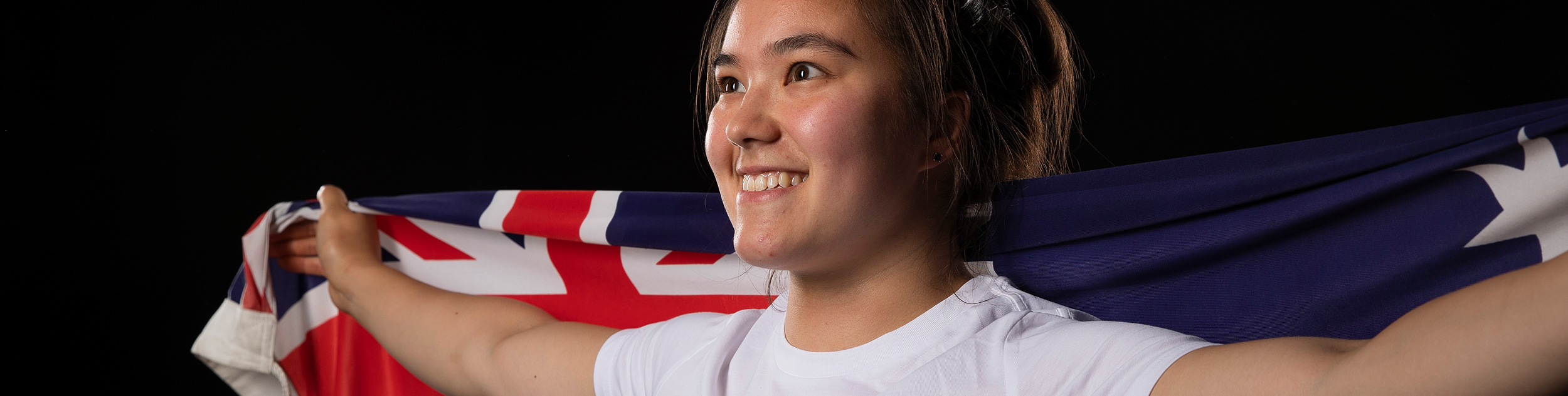 Kiana Elliott holds up the Australian flag behind her
