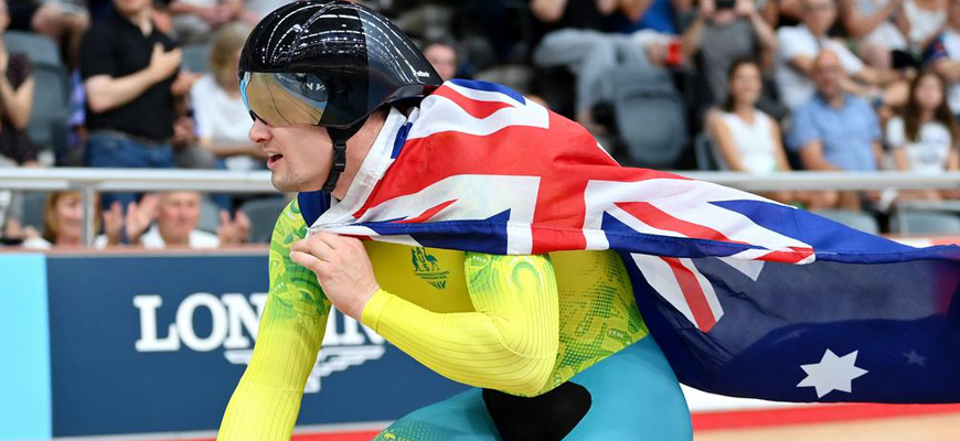 Matthew Glaetzer rides with the Australian flag around his shoulders