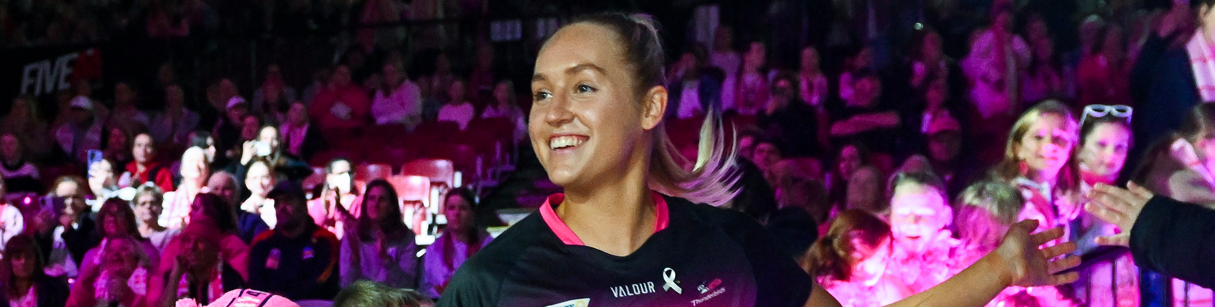 Tayla Williams smiling and high fiving the crowd